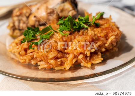 Bowl of east African Jollof Rice garnished with pieces of roasted chicken 90574979