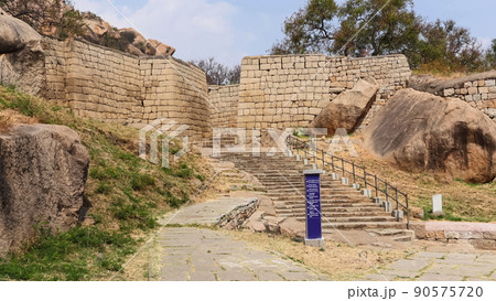 Beige Rampart walls of Chitradurga Fort and a signboard showing directions to the different landmarks, Karnataka, India Beige Rampart walls of Chitradurga Fort and a signboard showing directions to the different landmarks, Karnataka, India 90575720