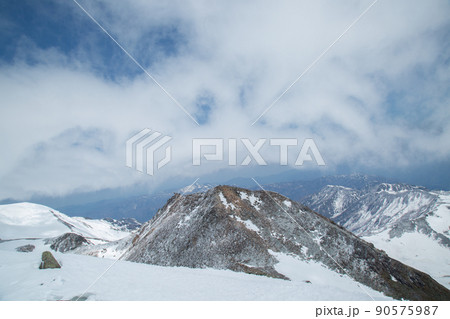 〔石川県／岐阜県・4月〕白山連峰御前峰山頂からの眺め　剣ヶ峰山頂部と荒ぶる雲 90575987