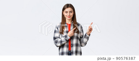 Lifestyle, different emotions, leisure activities concept. Determined smiling female student pointing fingers upper right corner, inform freshman new opportunities, educational program 90576387