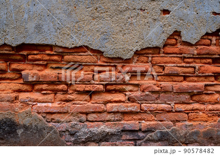 Old wall of stone bricks and grey plaster 90578482