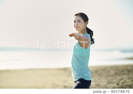 砂浜でヨガをする若い女性 90578670