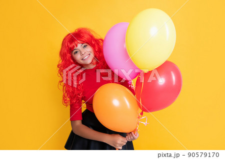 glad kid with party balloon on yellow background glad kid with party balloon on yellow background 90579170