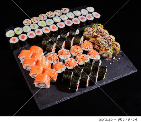 Different types of sushi roll set with salmon, vegetables, fish, avocado, caviar and sesame seeds. 90579754