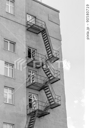 Silhouette of a fire escape on a high-rise building against a blue sky Silhouette of a fire escape on a high-rise building against a blue sky 90580719