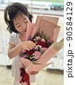 beautiful cute little girl holds flower bouquets in her hand 90584129