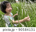 Beautiful little cute girl is picking up flower in the grass field with copy space 90584131