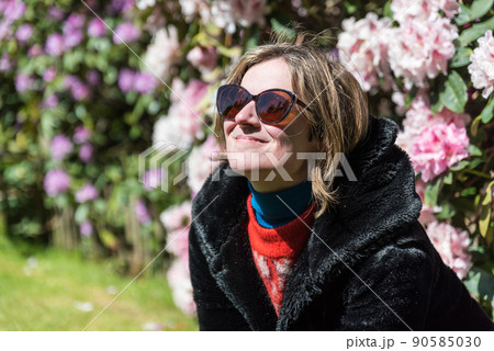 Attractive thirty year old woman posing in the sun, in a Brussels citypark during spring Attractive thirty year old woman posing in the sun, in a Brussels citypark during spring 90585030