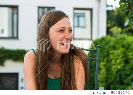 Portrait of an attractive thirty year old white woman in summer clothes posing on a sunny  terrace 90585170