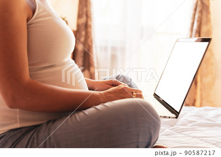 Pregnancy digital screen mockup. Pregnant woman holding blank laptop screen. Mobile pregnancy online maternity application mock up. Concept of pregnancy, maternity, expectation for baby birth. Pregnancy digital screen mockup. Pregnant woman holding blank laptop screen. Mobile pregnancy online maternity application mock up. Concept of pregnancy, maternity, expectation for baby birth. 90587217