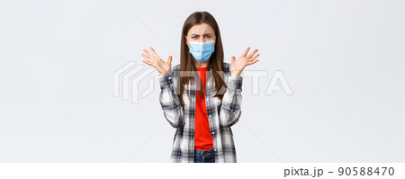 Different emotions, covid-19 pandemic, coronavirus self-quarantine and social distancing concept. Angry, outraged woman in medical mask, arguing, look mad, raise hands in dismay, complaining Different emotions, covid-19 pandemic, coronavirus self-quarantine and social distancing concept. Angry, outraged woman in medical mask, arguing, look mad, raise hands in dismay, complaining 90588470