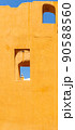Vertical photo of a yellow wall with windows and blue sky 90588560