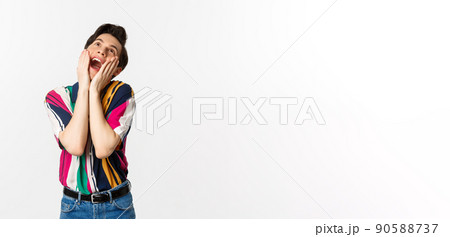 Image of excited gay man shouting of joy and looking up, feeling ecstatic, standing against white background 90588737