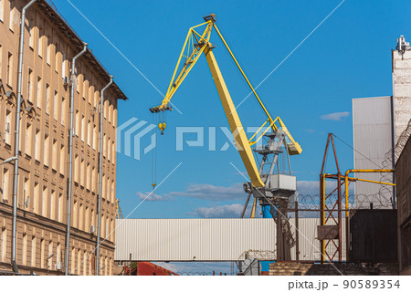 A crane in Baltic Shipyard against the blue sky - Saint Petersburg, Russia. A crane in Baltic Shipyard against the blue sky - Saint Petersburg, Russia. 90589354