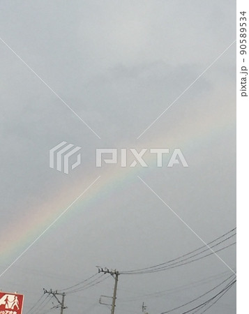 背景が曇り空で薄い虹がかかっている写真 90589534