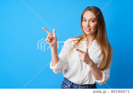Pretty nice young woman pointing to copy space for advertising 90590071