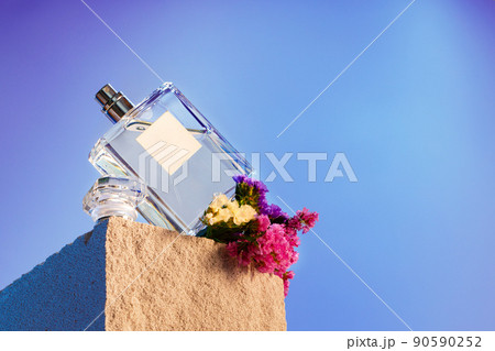 Transparent fragrance bottle on gray .cinder block 90590252