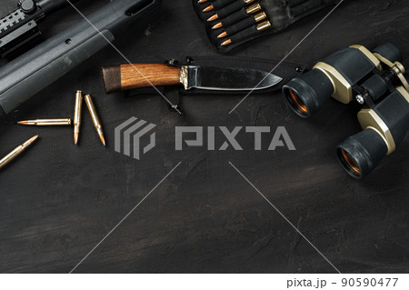 Hunting rifle and cartridges on dark wooden background 90590477