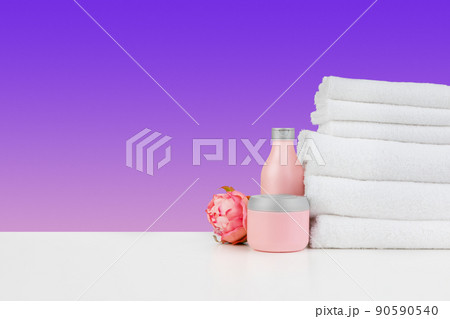 Stacked clean towels on white table against color background 90590540