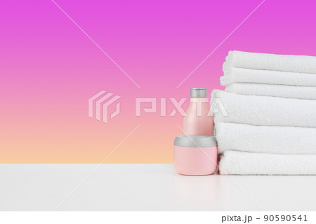 Pile of towels, bottles with shampoo on white table 90590541