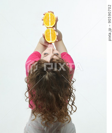 attractive girl with oranges in her hands photo shoot in the studio on a white background 90590702