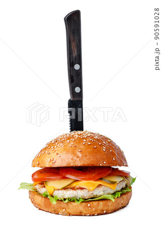 Cooked burger with pinned knife isolated on white Cooked burger with pinned knife isolated on white 90591028