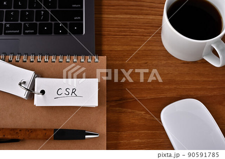 ノートパソコンとコーヒーカップ、そしてCSRと書かれた付箋紙がある。企業の社会的責任の略称。 ノートパソコンとコーヒーカップ、そしてCSRと書かれた付箋紙がある。企業の社会的責任の略称。 90591785