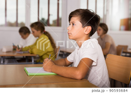 Schoolboy posing in classroom during lesson Schoolboy posing in classroom during lesson 90593684