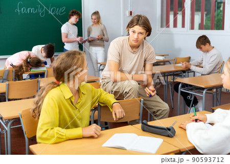 Teenagers resting and talking during recess in classroom Teenagers resting and talking during recess in classroom 90593712