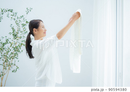 洗濯物を干すシニア女性 90594380