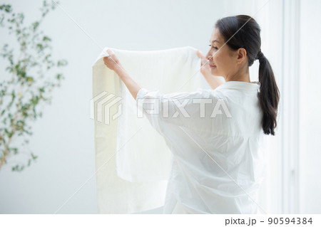 洗濯物を干すシニア女性 90594384