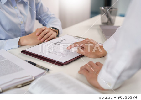 Business concept, Business colleague pointing on document to explain financial data to partner Business concept, Business colleague pointing on document to explain financial data to partner 90596974