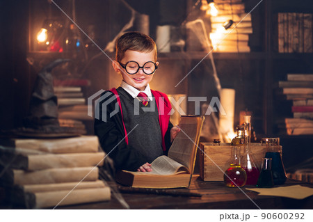 Small smiling wizard reads magic book Cosplay. Halloween holiday. Halloween costume party 90600292