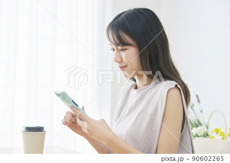 リビングでスマホを使う女性 リビングでスマホを使う女性 90602265