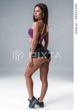 Brunette sexy fitness girl in sport wear with perfect body in the studio posing before training set. Big Booty Brunette sexy fitness girl in sport wear with perfect body in the studio posing before training set. Big Booty 90602360