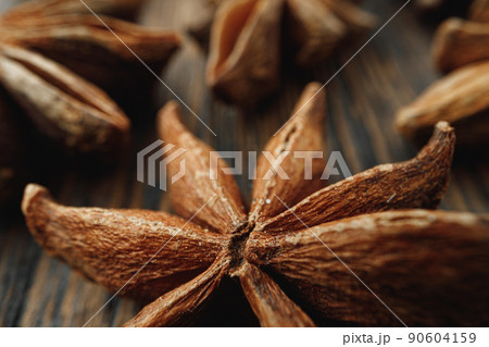 Macro photo of anise stars on wooden background Macro photo of anise stars on wooden background 90604159