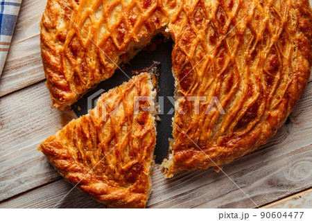 Sliced baked meat pie on wooden plate Sliced baked meat pie on wooden plate 90604477