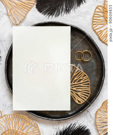Black and golden wedding table setting with a blank card and rings top view, mockup 90609855