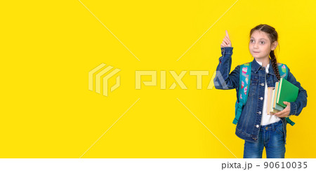 The schoolgirl with backpack wearing casual jeans denim shirt outfit isolated on yellow background 90610035