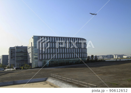 キング スカイフロント　ペプチドリームの上空を離陸中の旅客機 90612652