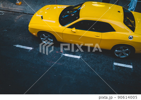 Yellow car parked on city street 90614005