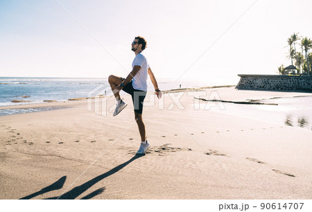 Young man lifting knee while having workout 90614707
