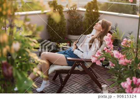 Dreamy Woman Holding a Book to Chest 90615324