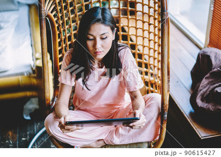 Millennial woman with touch pad technology checking received messages 90615427