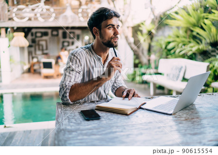 Thoughtful ethnic man with laptop and notebook 90615554