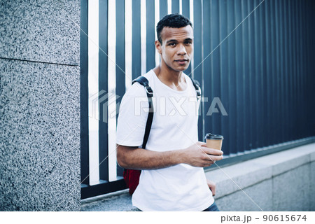 Serious black male enjoying coffee on street 90615674