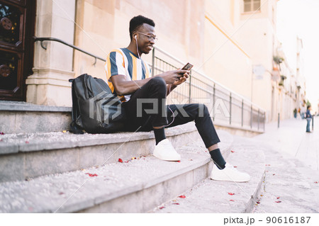 Happy male blogger in headphones checking received email and network publication 90616187