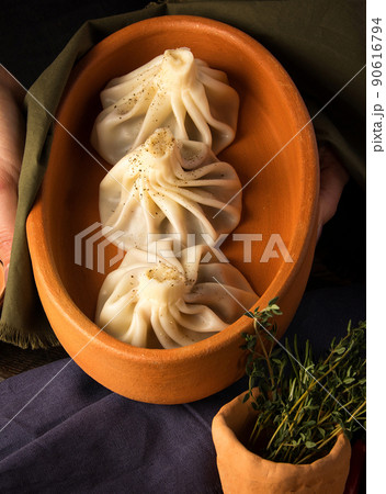 Vertical shot of a luxurious restaurant table with a gourmet khinkali dish Vertical shot of a luxurious restaurant table with a gourmet khinkali dish 90616794