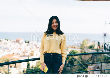 Cheerful female traveller posing in town 90616798