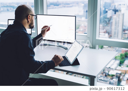 Unrecognizable male worker analyzing data on desktop computer in office 90617312